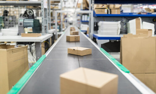 Cardboard boxes on conveyor belt at distribution warehouse